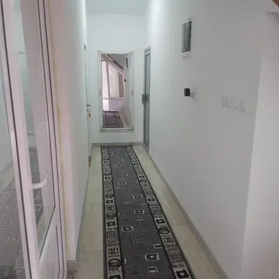 a hallway with a rug on the floor next to a door at Yugoslavija 2 centar in Aleksandrovac