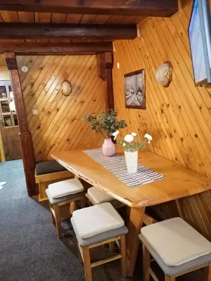 a room with a wooden table and chairs at VILA 51 KOPAONIK CENTAR in Kopaonik