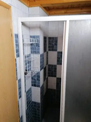 a shower with blue and white tiles in a bathroom at VILA 51 KOPAONIK CENTAR in Kopaonik