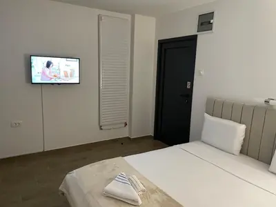a bedroom with a bed and a tv on the wall at Prenociste 