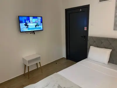 a bedroom with a bed and a tv on the wall at Prenociste 