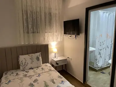 a small bedroom with a bed and a television at Prenociste 