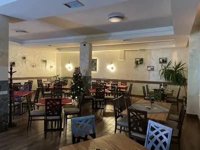 a restaurant with tables and chairs and a christmas tree at Prenociste 