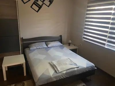 a bedroom with a bed with a pillow and a window at Arni apartments in Donja Vrežina