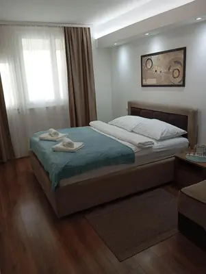 a bedroom with a bed with two towels on it at Apartman Leon Lux in Leskovac