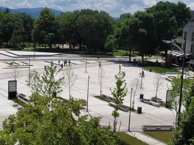 a large parking lot with people walking around in a park at Apartman Leon Lux in Leskovac