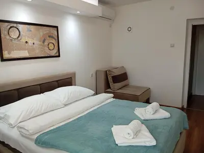 a bedroom with a bed with towels on it at Apartman Leon Lux in Leskovac