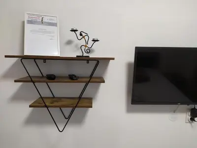 a flat screen tv sitting next to a shelf at Apartman Leon Lux in Leskovac