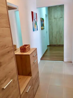 a room with a wooden dresser and a mirror at Apartman Leon Lux in Leskovac