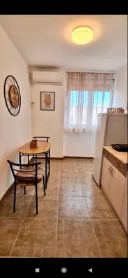 a kitchen with a table and a table and a refrigerator at Apartman Leon Lux in Leskovac