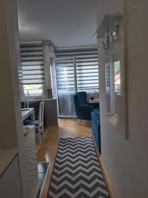 a living room with a blue couch and a table at Dora Lux & Free Indoor Parking in Vrnjačka Banja