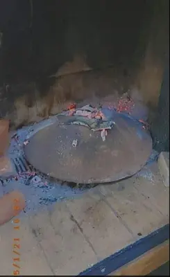 a pizza is cooking in a stone oven at Vila KTM Lisine in Despotovac