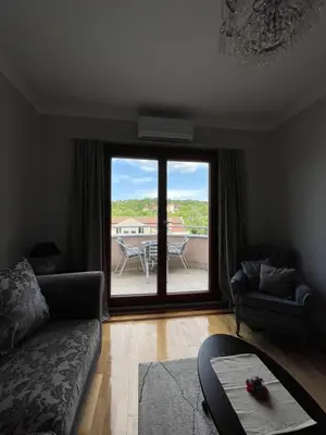 a living room with a couch and a view of a patio at Apartman AS in Vrnjačka Banja