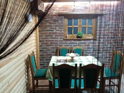 a dining room with a table and chairs and a window at Apartman Konak in Zaječar