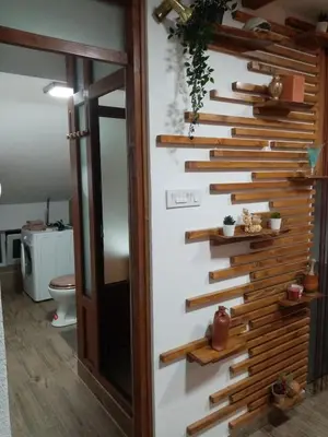 a bathroom with a wall with wooden stairs at Apartman Konak in Zaječar
