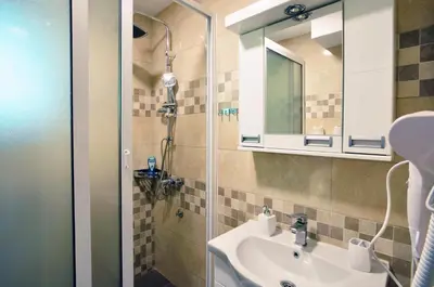 a bathroom with a sink and a mirror at Stil Park Apartmani in Vrnjačka Banja