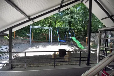 a view of a playground through a window at Stil Park Apartmani in Vrnjačka Banja