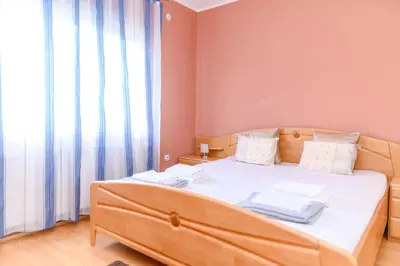 a bedroom with a bed with white sheets and a window at Arsic-Home in Soko Banja