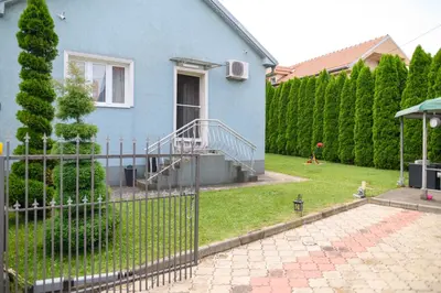 a blue house with a fence in a yard at Arsic-Home in Soko Banja