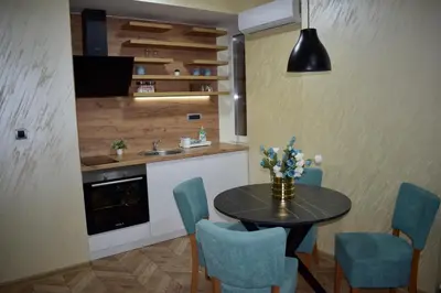 a kitchen with a table and chairs and a sink at Pink House Apartments in Jagodina