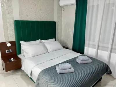 a bedroom with a bed with two towels on it at Pink House Apartments in Jagodina