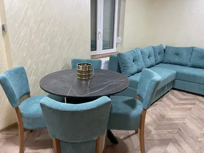 a living room with a couch and a table and chairs at Pink House Apartments in Jagodina