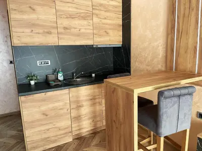 a kitchen with wooden cabinets and a sink at Pink House Apartments in Jagodina