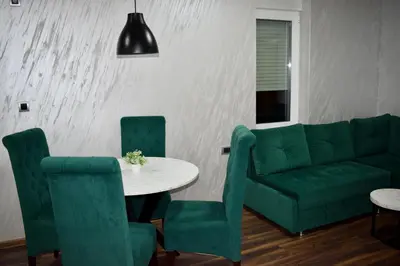 a living room with a couch and a table and chairs at Pink House Apartments in Jagodina