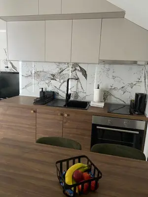 a kitchen with a basket of fruit on a table at Apartmani Lazarevic Jagodina in Jagodina