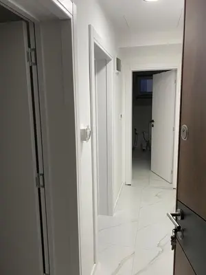 a bathroom with a mirror and a white tile floor at Apartmani Lazarevic Jagodina in Jagodina