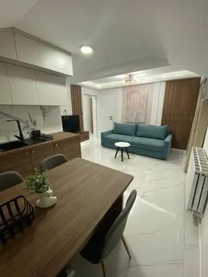a living room with a table and a blue couch at Apartmani Lazarevic Jagodina in Jagodina