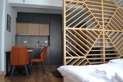a bedroom with a wooden staircase leading to a kitchen at President Kop A 14 in Cajetina