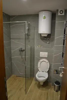 a bathroom with a toilet and a glass shower at President Kop A 14 in Cajetina