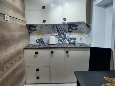 a kitchen with white cabinets and a counter top at Apartment Sweet dreams 4 in Niš