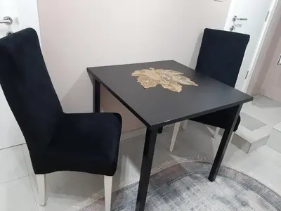 a black table with two chairs and a flower on it at Apartment Sweet dreams 4 in Niš
