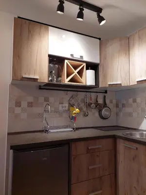 a kitchen with wooden cabinets and a sink at Promenada View Snežnik in Vrnjačka Banja