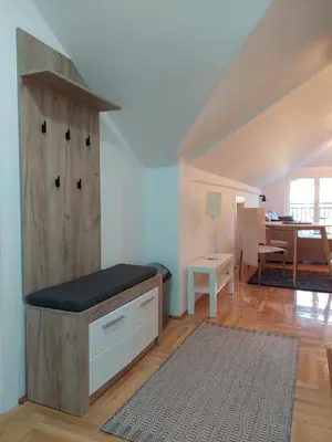 a kitchen with a wooden cabinet and a dining room at Promenada View Snežnik in Vrnjačka Banja