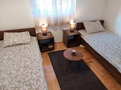 a living room with two beds and a table at Promenada View Snežnik in Vrnjačka Banja