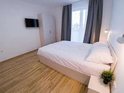 a bedroom with a large white bed and a window at Milutinn-Visterija in Soko Banja
