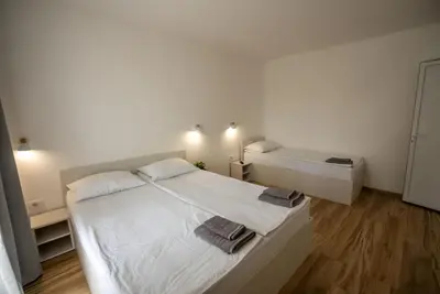 a white bedroom with a bed and a bath tub at Milutinn-Visterija in Soko Banja