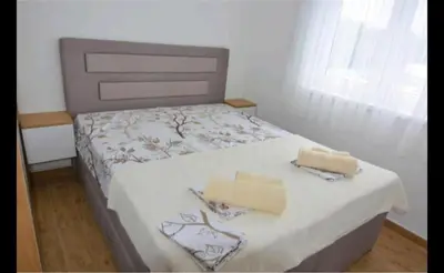 a bedroom with a bed with two boxes on it at Neda Lux Apartmani 5 nocenja, šesto gratis in Vrnjačka Banja