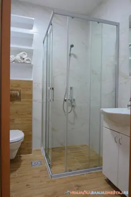 a bathroom with a shower and a toilet and a sink at Neda Lux Apartmani 5 nocenja, šesto gratis in Vrnjačka Banja