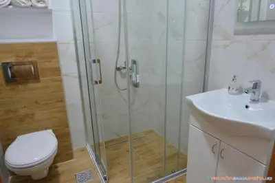 a bathroom with a shower and a toilet and a sink at Neda Lux Apartmani 5 nocenja, šesto gratis in Vrnjačka Banja