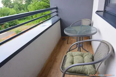 a balcony with two chairs and a table and a window at Neda Lux Apartmani 5 nocenja, šesto gratis in Vrnjačka Banja