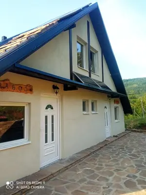 a house with a blue roof at Zavojsko jezero - Vila Jezero in Pirot