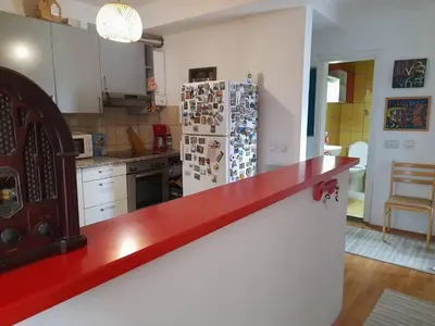 a kitchen with a red counter top and a refrigerator at Family Apartman in Jagodina