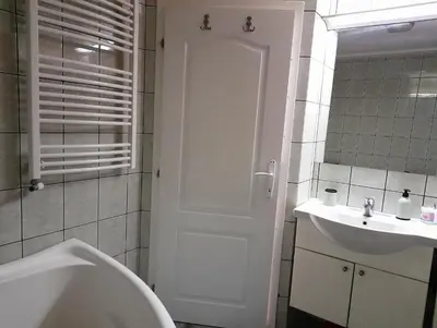 a bathroom with a tub and a toilet and a sink at Family Apartman in Jagodina