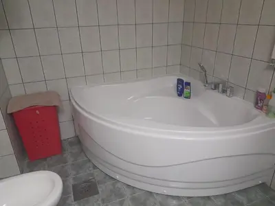 a white bath tub in a bathroom with a toilet at Family Apartman in Jagodina