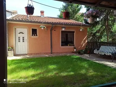 a house with a yard with a bench in front of it at Apartman Mila in Niš