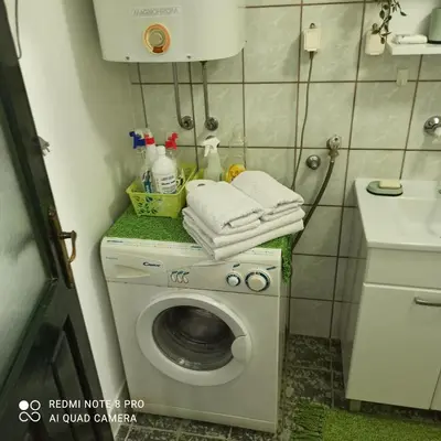 a bathroom with a washing machine with towels on it at Apartman Mila in Niš